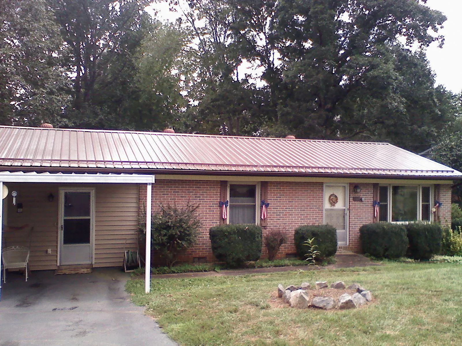 Bronze metal roof and carport on a brick ranch home — Roof Repair work by our crew in Sagle